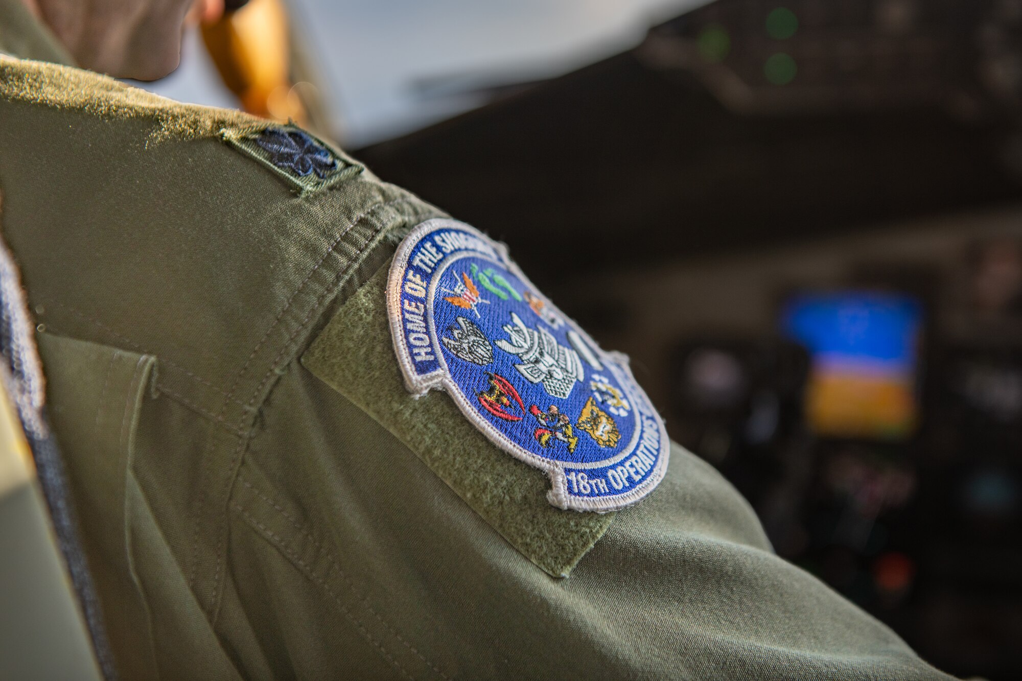 The patch on the shoulder of a pilot shines in the light of the setting sun