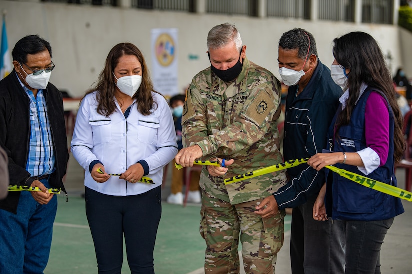 U.S. Army Col. Franklin Florence, the Joint Task Force Bravo dentist, center, cuts the ribbon during an opening ceremony at a global health engagement in Aquacatan, Guatemala, Dec. 15, 2021.