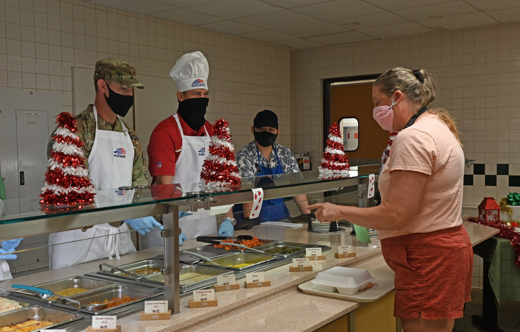 15th Wing Leadership serves airmen and families Christmas eve lunch at the Hale Aina Dining Facility, Dec. 24, 2021. Leaders from Joint Base Pearl Harbor-Hickam were stationed at different sections of the dining facility to serve airmen. (U.S. Air Force photo by 1st Lieutenant Denise Guiao-Corpuz)
