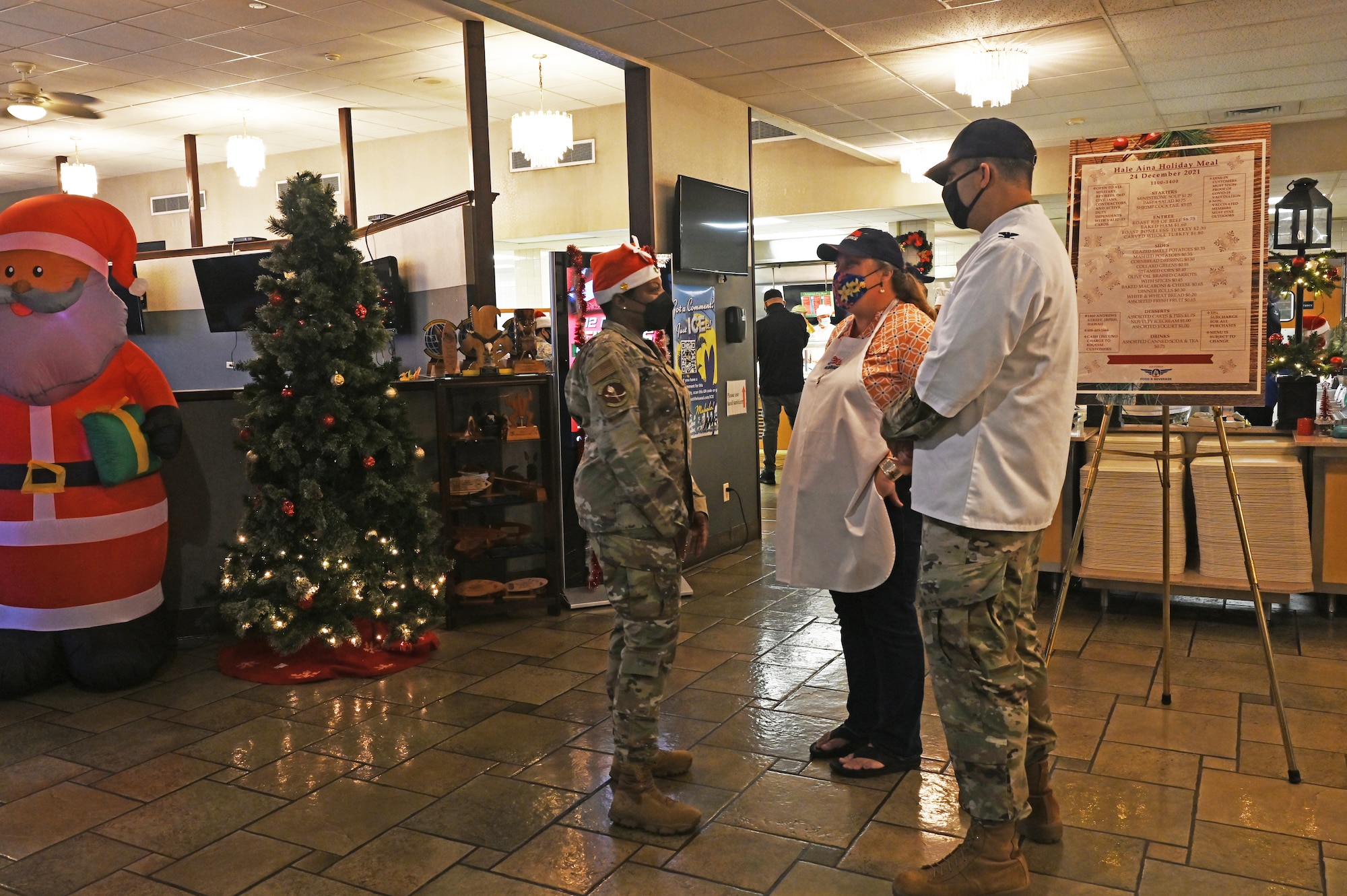 Col. Daniel Dobbels, 15th Wing commander and his wife, Lisa Dobbels greet airmen on Christmas eve at the Hale Aina Dining Facility, Dec. 24, 2021. Leaders from Joint Base Pearl Harbor-Hickam served airmen and their families lunch on Christmas eve. (U.S. Air Force photo by 1st Lieutenant Denise Guiao-Corpuz)