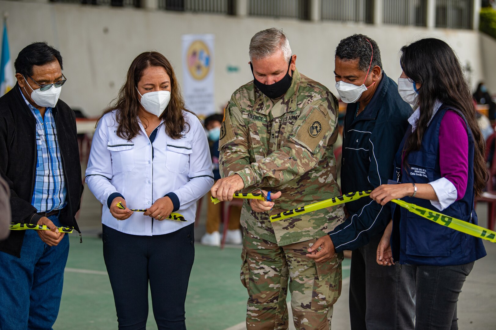 U.S. Army Col. Franklin Florence, the Joint Task Force Bravo dentist, center, cuts the ribbon during an opening ceremony at a global health engagement in Aquacatan, Guatemala, Dec. 15, 2021.