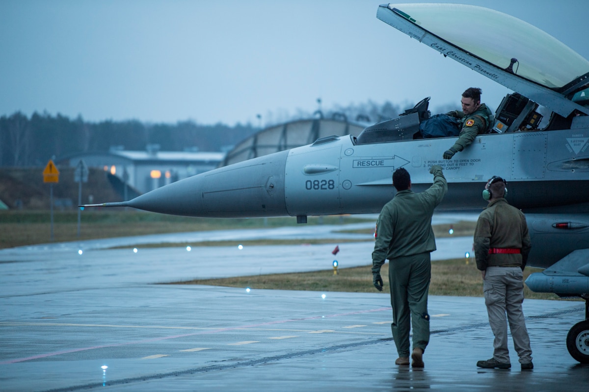 U.S. Air Force F-16 Fighting Falcon pilots assigned to the 480th Fighter Squadron at Spangdahlem Air Base, Germany, greet each other after arriving at Łask Air Base, Poland, January 4, 2022.