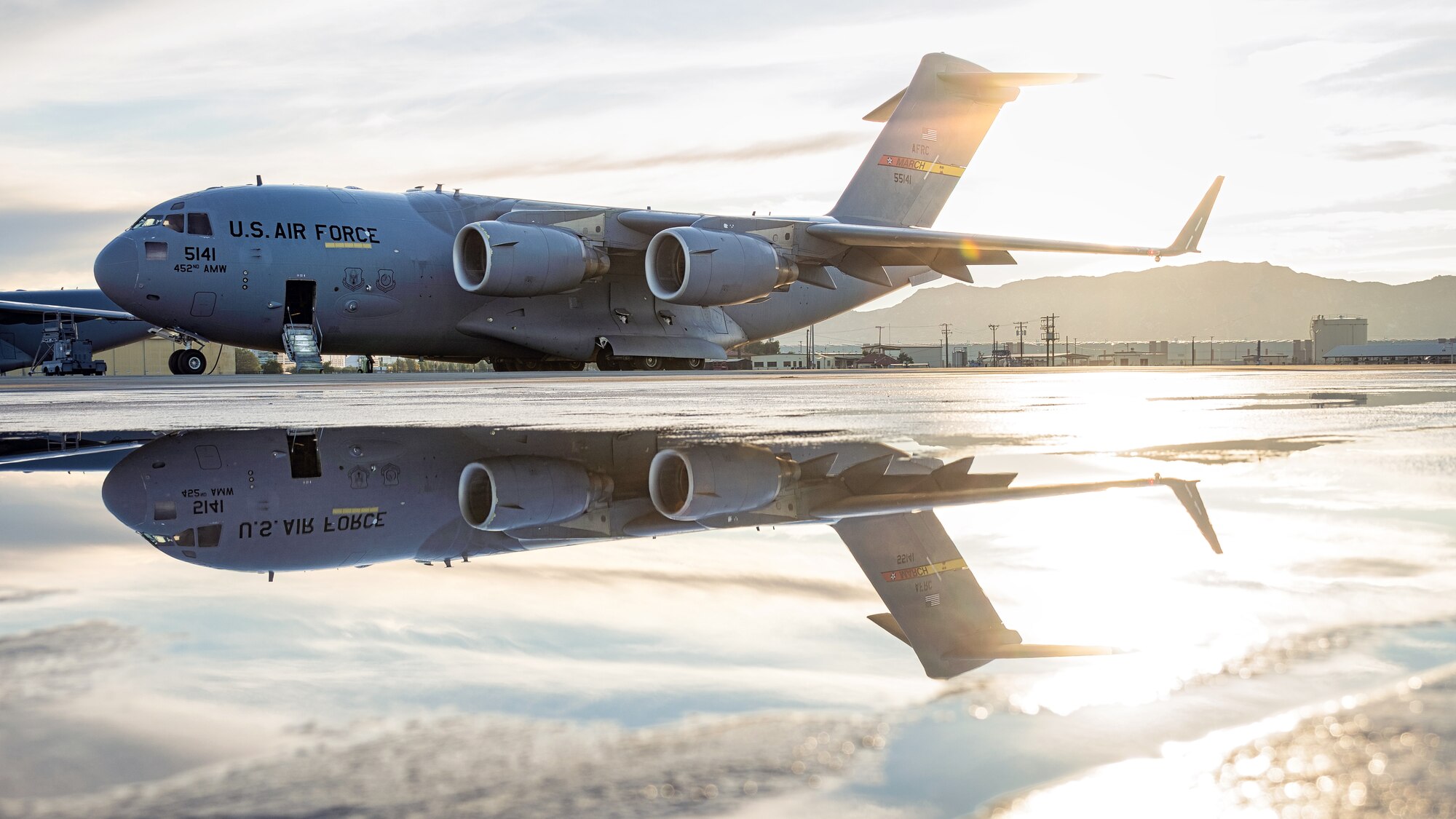 The sun rises over a C-17 Globemaster III on the flight line