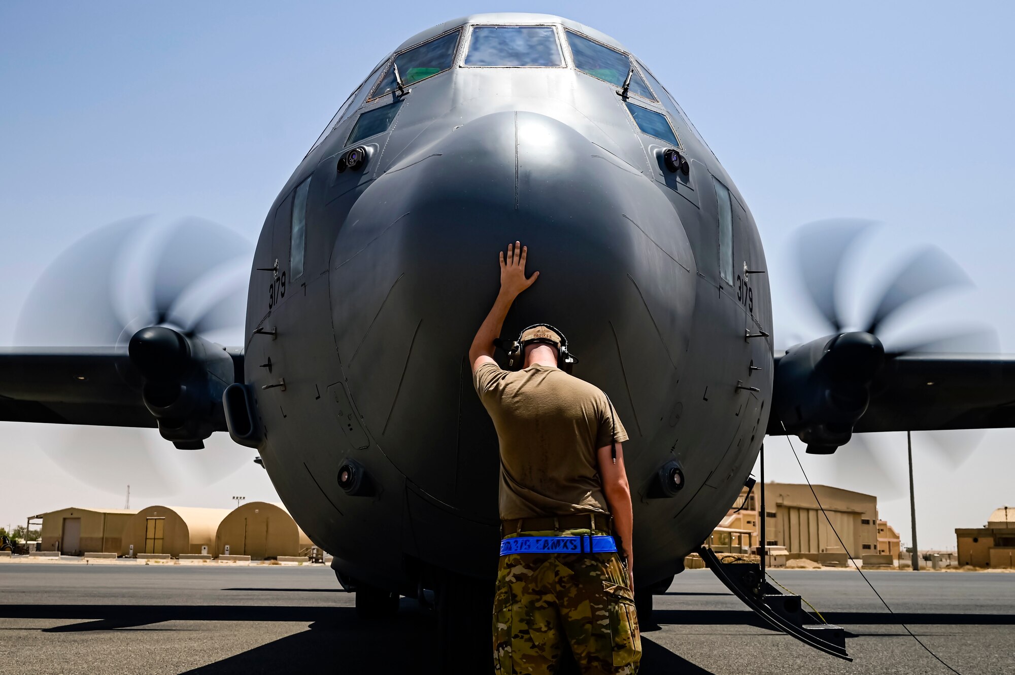 40th Expeditionary Airlift Squadron flying crew chief touches the nose of a C-130J Super Hercules