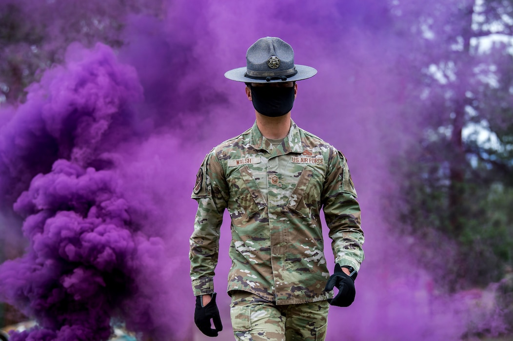 Master Sgt. Michael Walsh, military training instructor, walks through purple smoke
