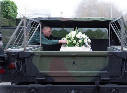 Martin Van Dijk, the best friend and a fellow co-worker of Wiel Hendriks, secures Hendriks’ casket to the back of a Humvee. The Humvee was used to transport Hendriks to his final resting place, by his request. Dijk and Hendriks, both Dutch Ministry of Defense employees, started working for the U.S. Army at the same time in 1986. (Photo by Fons Ljpelaar)