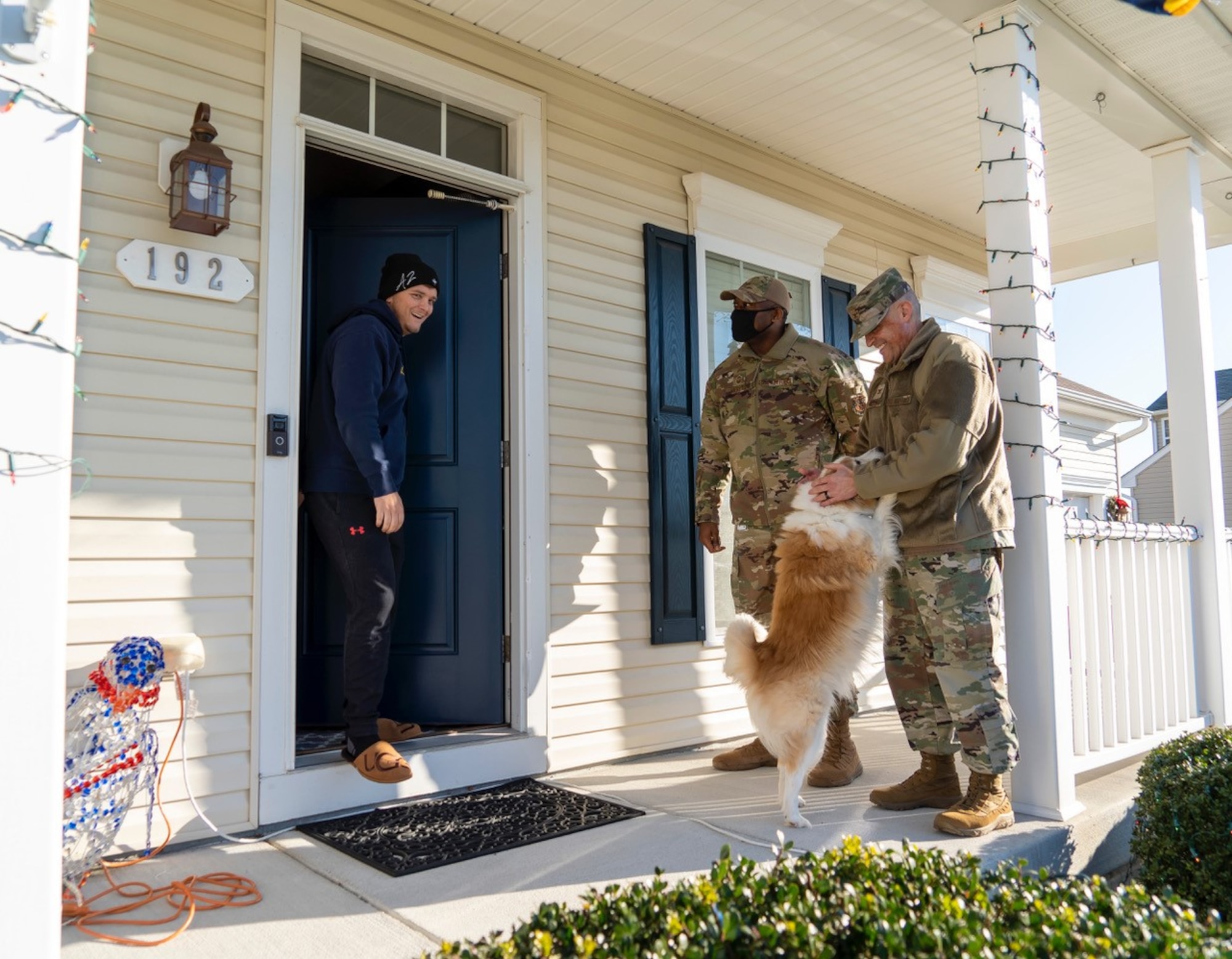 Col. Chip Hollinger, (right) Air Force Mortuary Affairs Operations commander and Chief Master Sgt. Bobby Drayton, AFMAO senior enlisted leader, surprise Staff Sgt. Jacob Jones, AFMAO unit deployment manager, at his home Dec. 23, 2021, to notify him of his selection for promotion under the Stripes of Exceptional Performers program. Jones was promoted to the rank of Tech. Sgt., effective Dec. 10, 2021. (U.S. Air Force photo by Jason Minto)