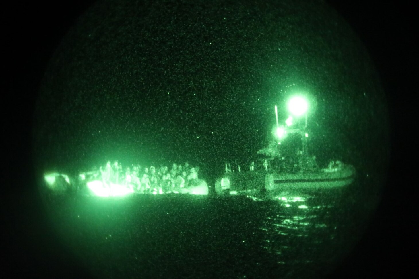 The crew of the Sentinel-class USCGC Glen Harris (WPC 1145) aboard a small boat assess an overloaded raft taking on water carrying migrants in the Atlantic Ocean prior to their subsequent rescue Jan. 5, 2021.