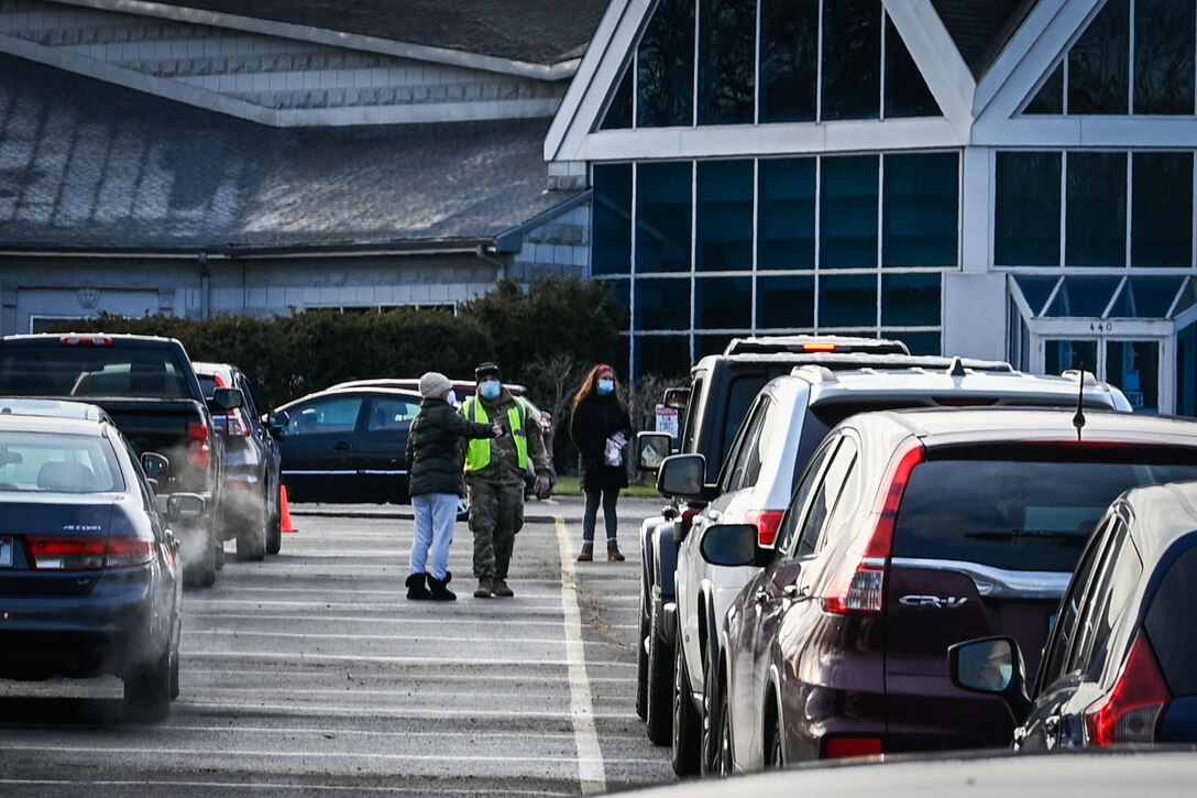 A soldier directs traffic at a state-supported COVID-19 testing site