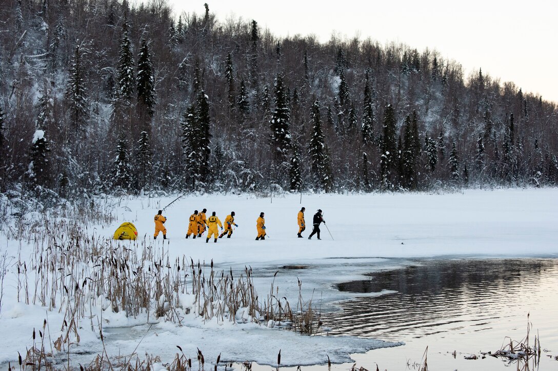 A group of people walk together across ice and snow.