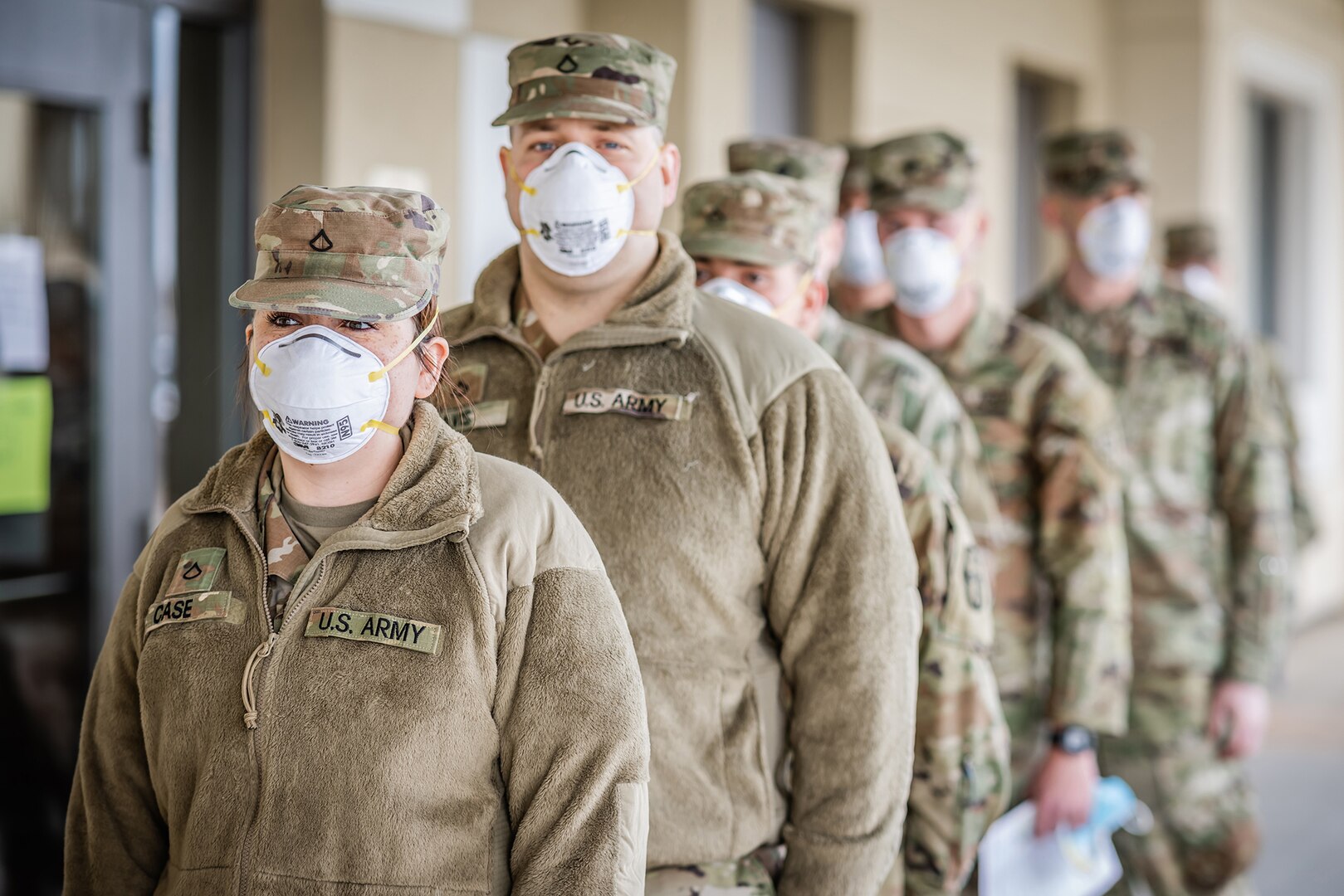 Guard members in OCPs line up outside the National Guard Center.