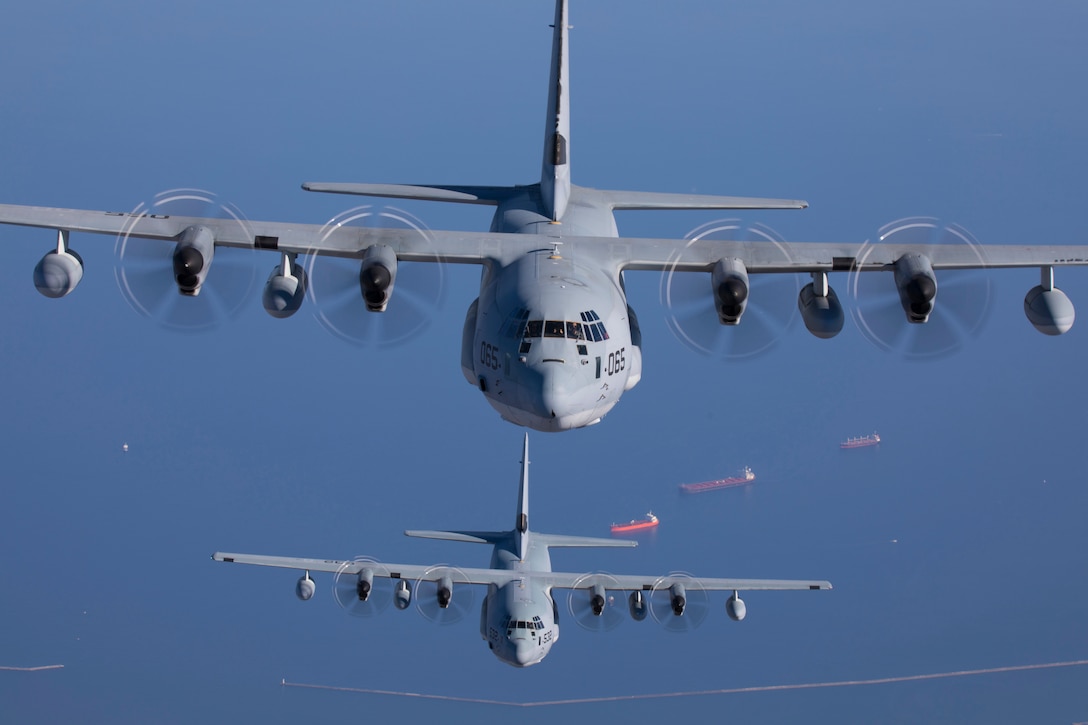 Two large planes fly in formation.