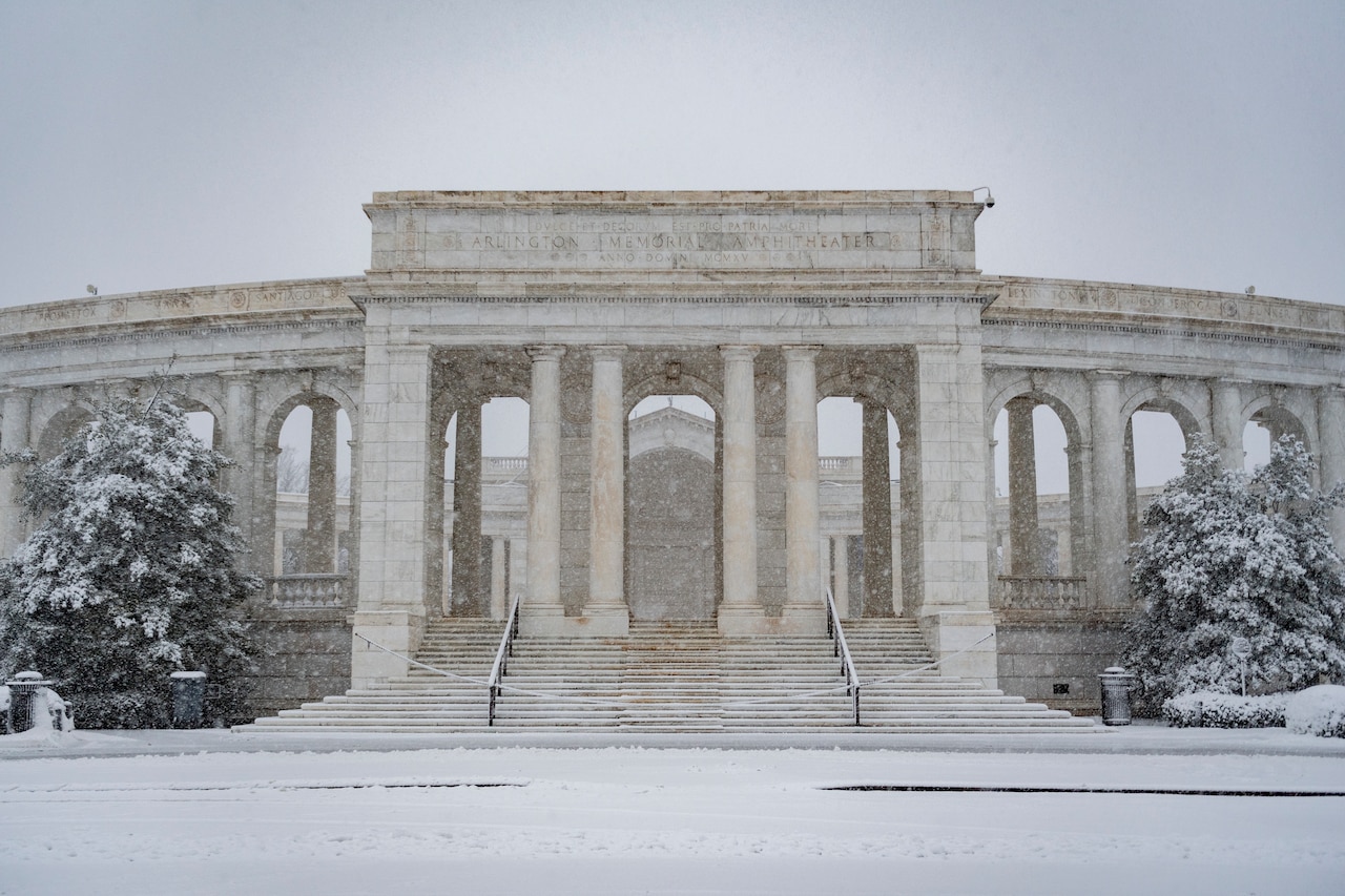 Snow falls on a building.