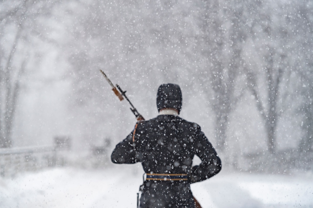 A soldier walks in the snow.