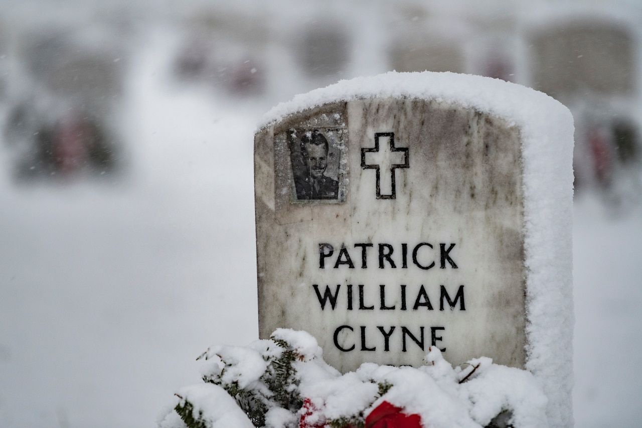 A headstone is covered in snow.