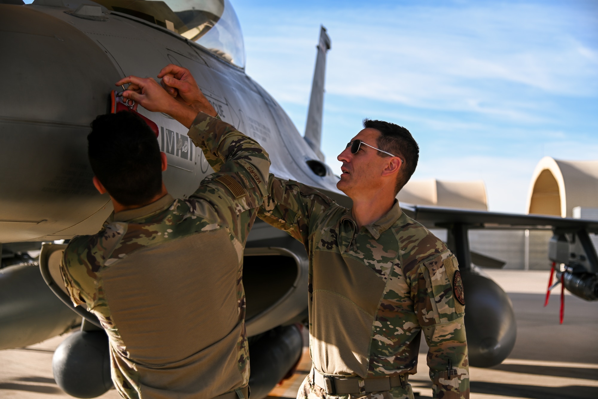 Senior Master Sgt. Steve Veers, 176th Expeditionary Fighter Squadron aerospace propulsion superintendent, and Airman 1st Class Isac Veers 176th EFS aviation resource management journeyman, inspect an F-16 Fighting Falcon at Prince Sultan Air Base, Kingdom of Saudi Arabia, Dec. 13, 2021. This deployment is the last of Steve’s 31 year career and the first for Isac. (U.S. Air Force photo by Staff Sgt. Christina Graves)