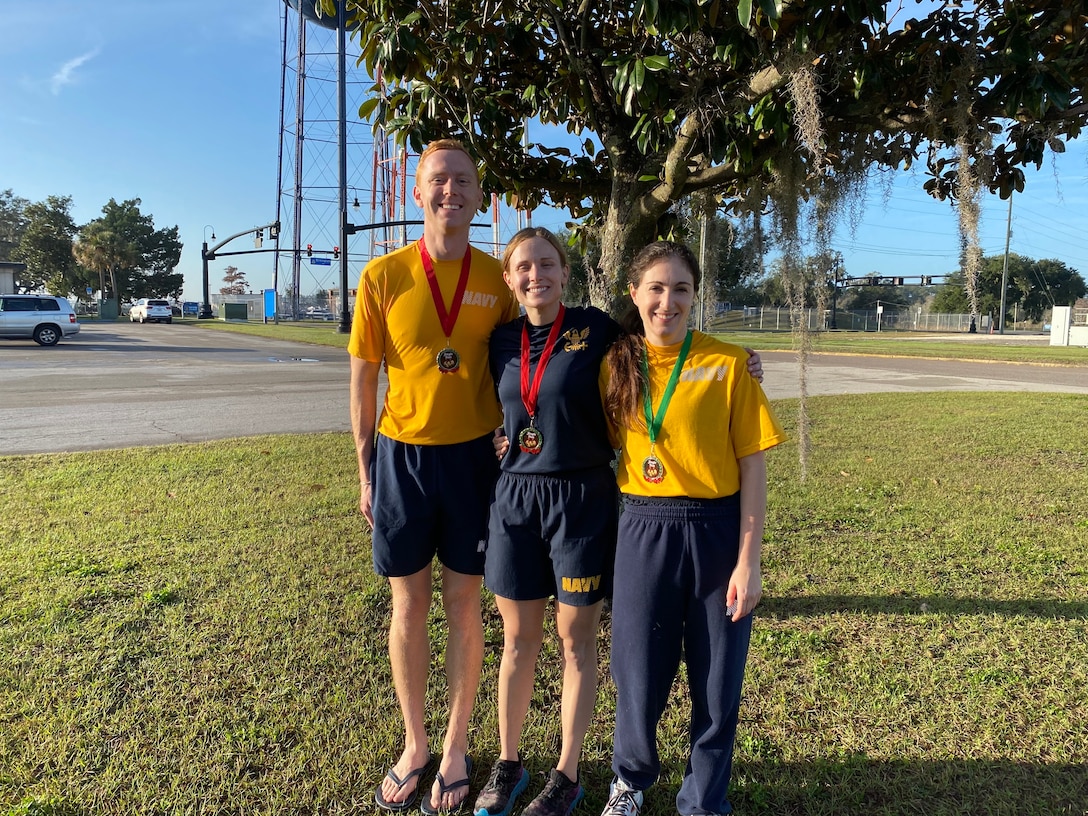 Lt. Jessica Fetzer, Lt. Danielle Zucker, and Lt. j.g. Ryan Fuller earn first-place medals at the Jingle Bell Jog 5K.