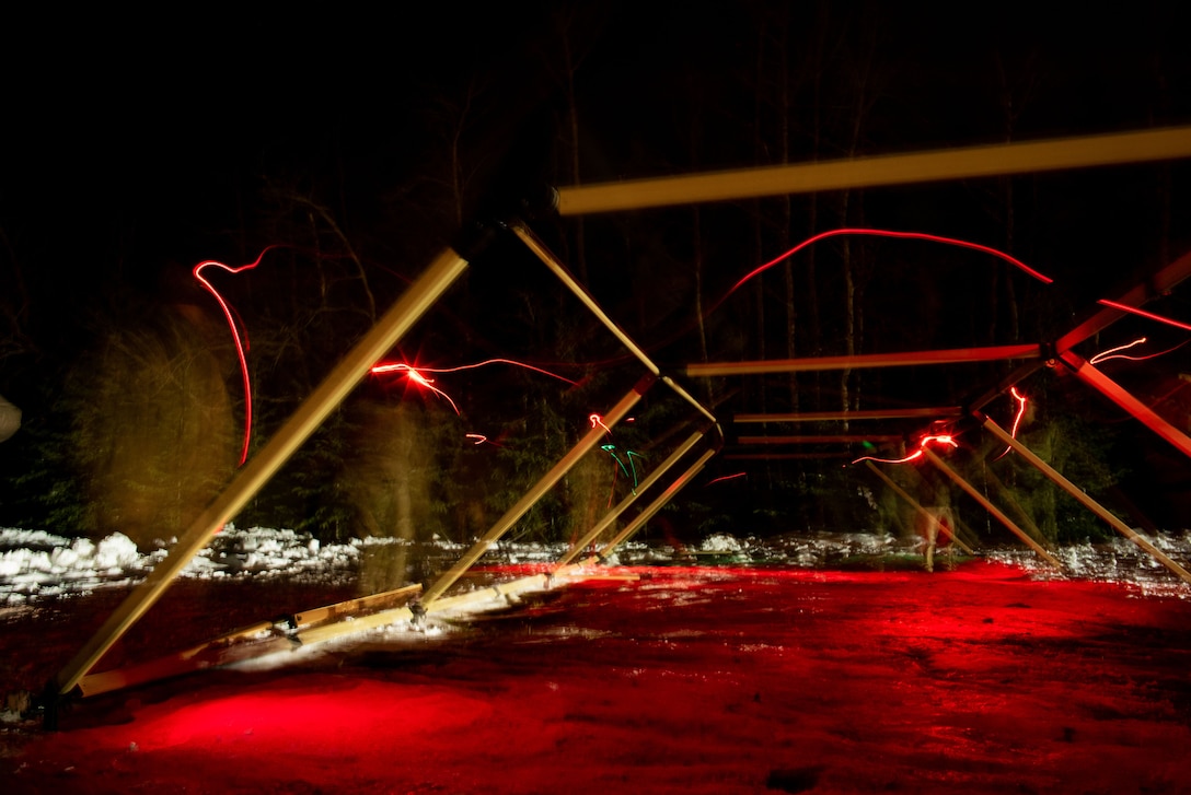 The frame of a tent is shown at night in red light.