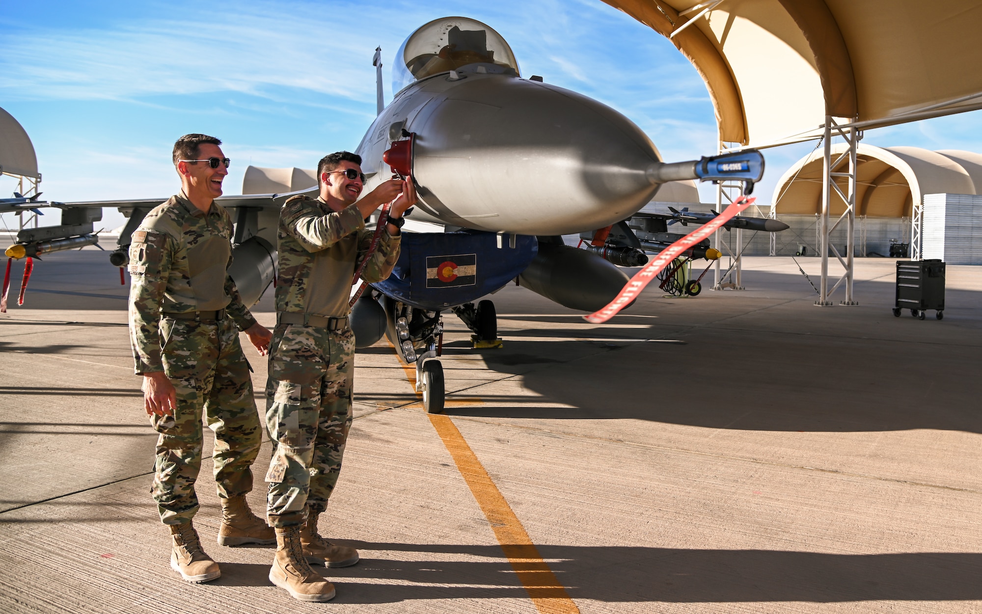 Senior Master Sgt. Steve Veers, 176th Expeditionary Fighter Squadron aerospace propulsion superintendent, and Airman 1st Class Isac Veers 176th EFS aviation resource management journeyman, inspect an F-16 Fighting Falcon at Prince Sultan Air Base, Kingdom of Saudi Arabia, Dec. 13, 2021. This deployment is the last of Steve’s 31 year career and the first for Isac. (U.S. Air Force photo by Staff Sgt. Christina Graves)