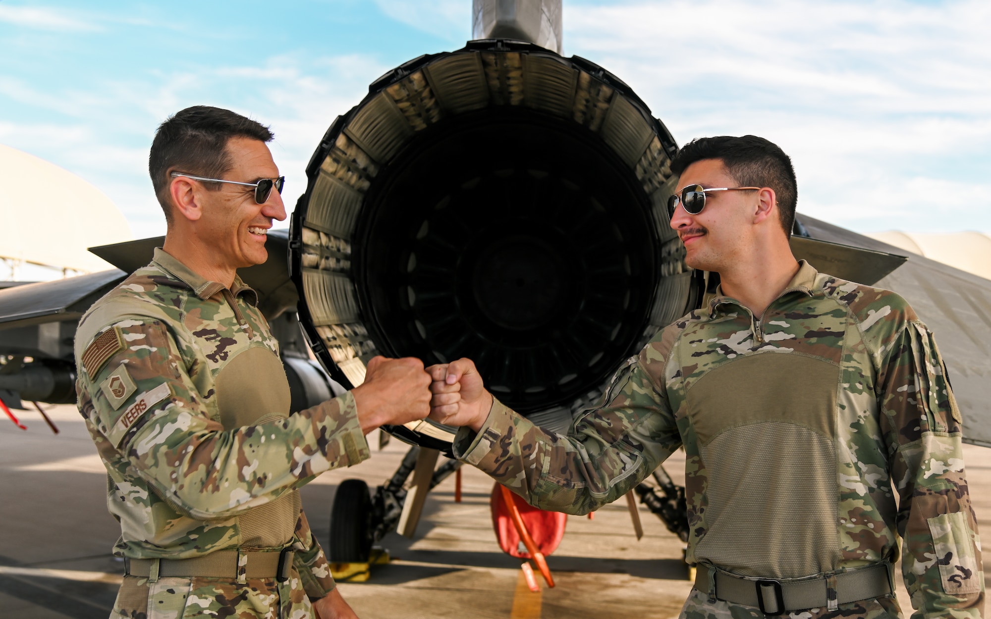 Senior Master Sgt. Steve Veers, 176th Expeditionary Fighter Squadron aerospace propulsion superintendent, and Airman 1st Class Isac Veers 176th EFS aviation resource management journeyman, pose for a photo in front of an F-16 Fighting Falcon at Prince Sultan Air Base, Kingdom of Saudi Arabia, Dec. 13, 2021. The father and son duo deployed to the 378th Air Expeditionary Wing together from the 115th Fighter Wing, Madison, Wisconsin. (U.S. Air Force photo by Staff Sgt. Christina Graves)