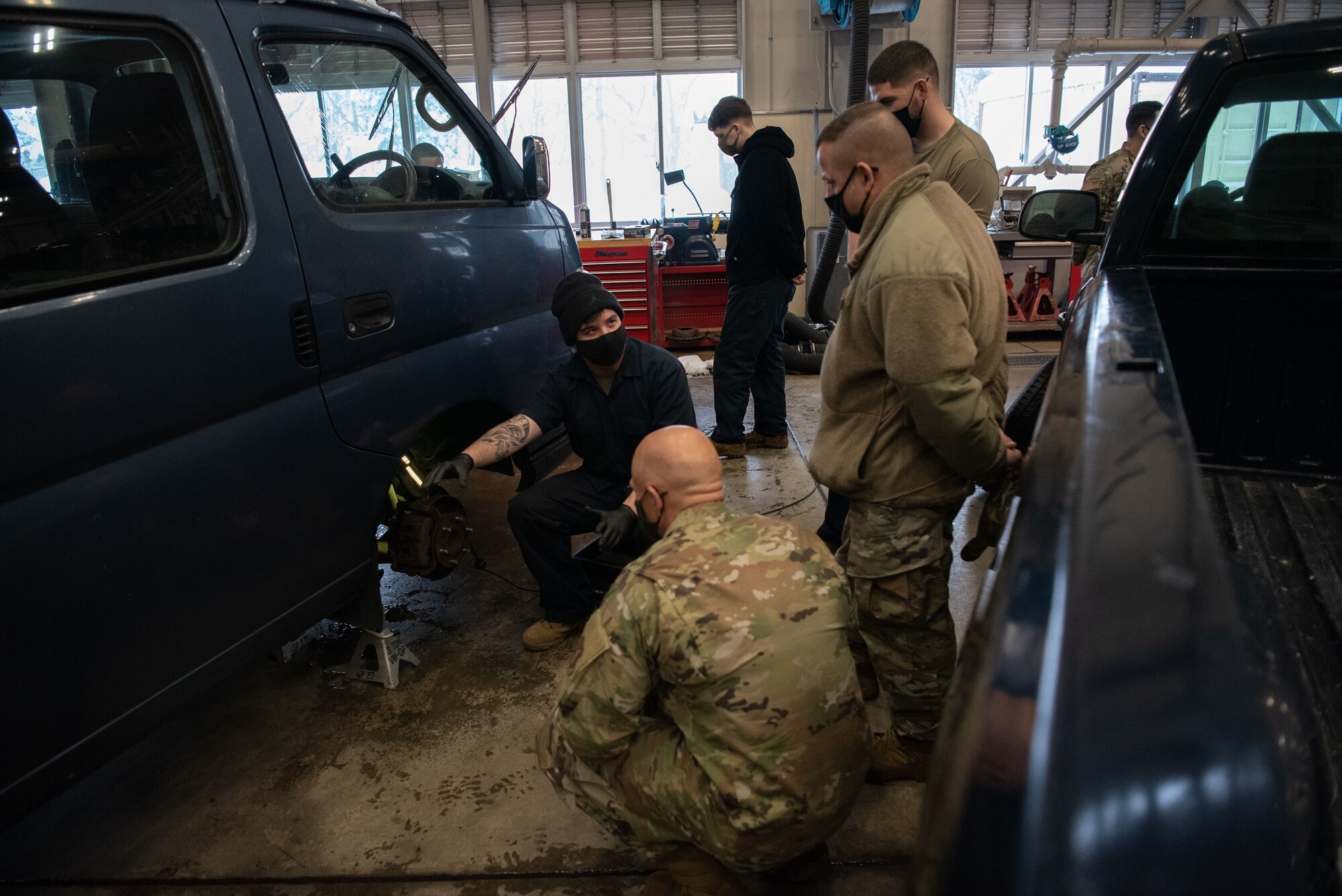 A military member shows the colonel and chief what is being worked on.