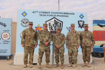 From left, Command Chief Warrant Officer 5 Rich Huber, Sgt. 1st Class Robert Jones, Staff Sgt. Vergia Farrow, Col. Alan Gronewold and Command Sgt. Maj. Refugio Rosas in front of the Task Force Phoenix T-wall at Camp Buehring, Kuwait.