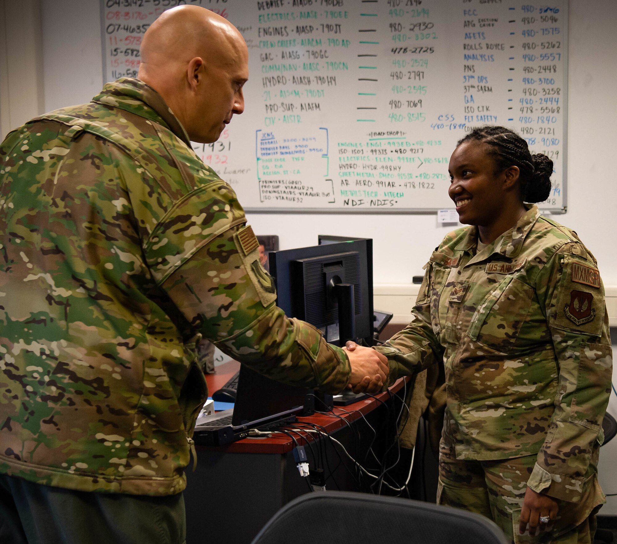Airman shakes hands with General during coining.
