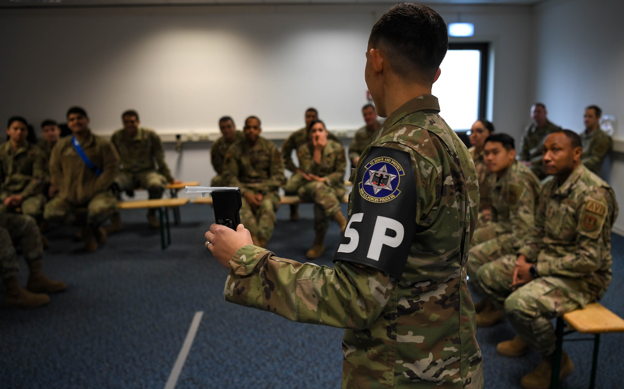 U.S. Air Force Staff Sgt. Madison Alicea, 569th United States Forces Police Squadron unit training instructor, explains to 86th Maintenance Group Airmen how the portable breathalyzer works to determine if someone is driving under the influence during a Wet Lab event at Ramstein Air Base, Germany, Dec. 16, 2021. The purpose of the Wet Lab event is to demonstrate how 569 USFPS personnel conduct standard field sobriety tests to determine if people are driving under the influence of alcohol to help deter someone from drinking and driving. (U.S. Air Force photo by Airman Jared Lovett)