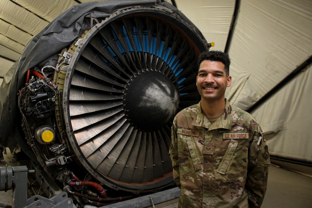 Staff Sgt. Dvonte Washburn stands in front of a KC-10 Extender engine in a maintenance hangar at Al Dhafra Air Base, United Arab Emirates, Jan. 5, 2022. Washburn is an Airman in the U.S. Air Force Reserve, deployed from Joint Base McGuire-Dix-Lakehurst.