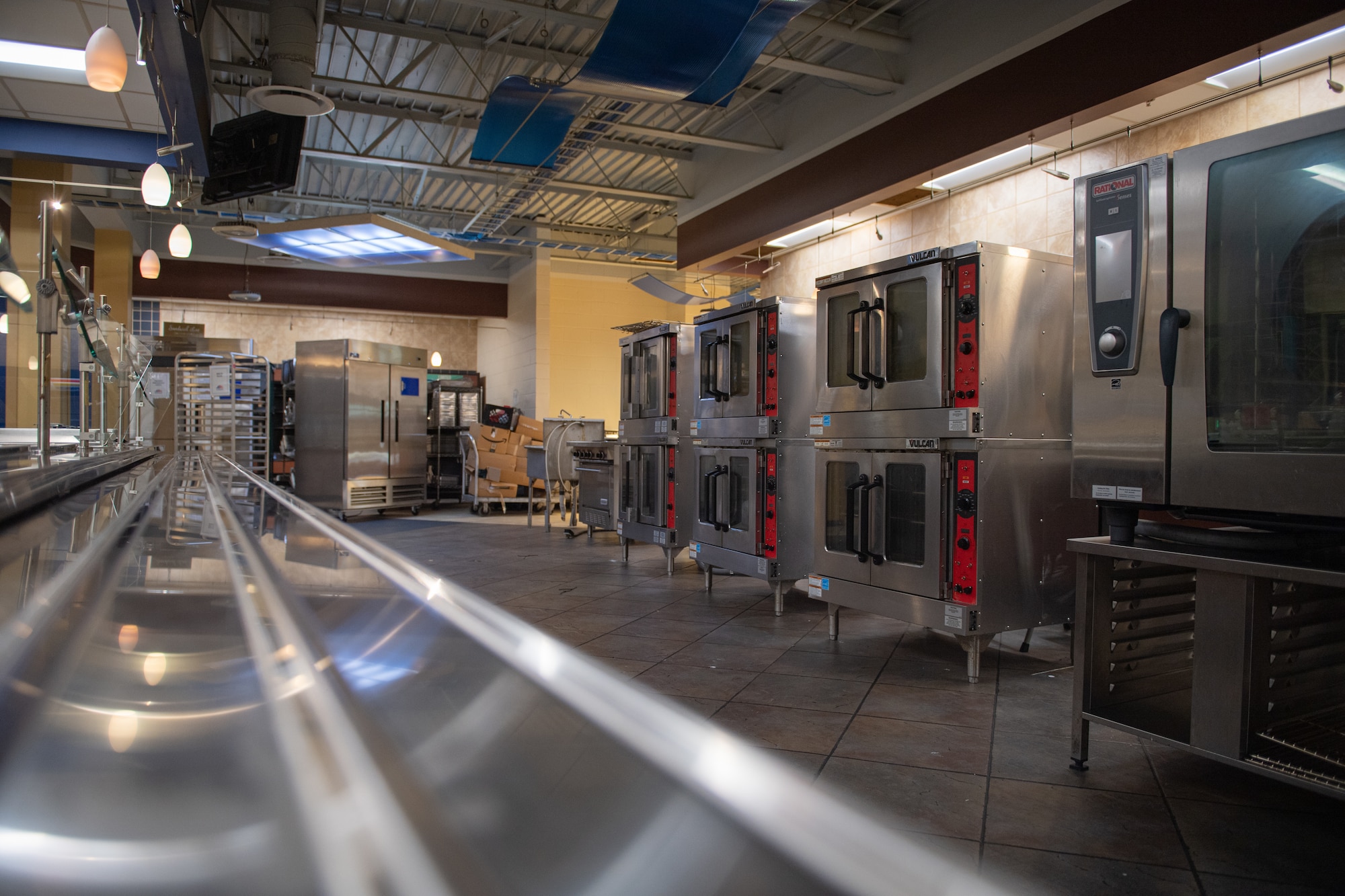 A photo of ovens in a row to the right of the photo, and a leading lines effect to draw your eyes to the cluttered room.