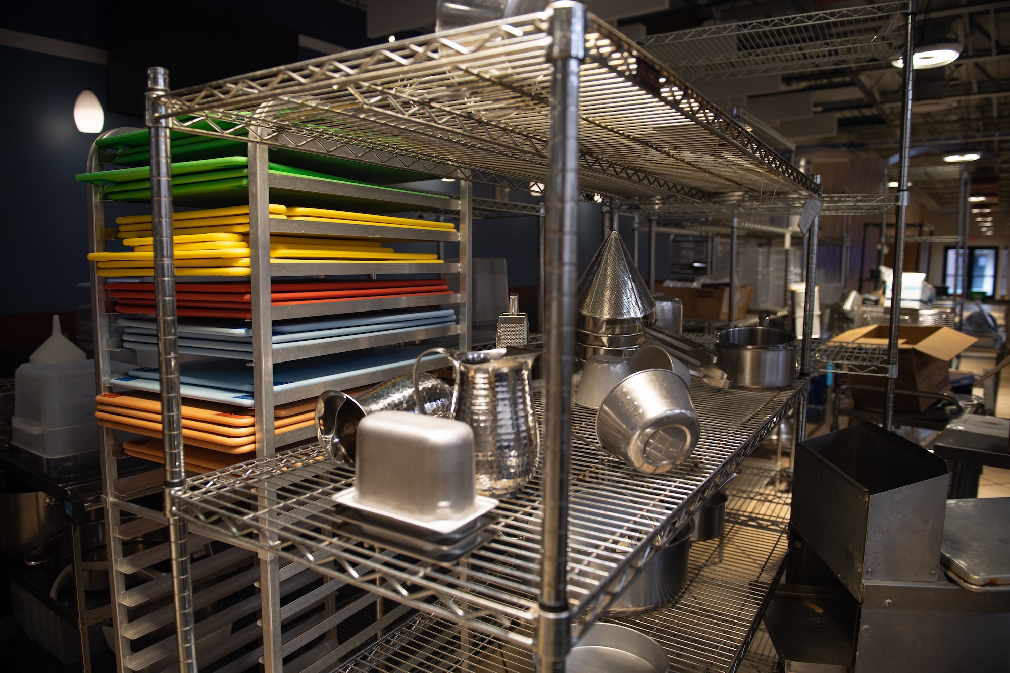 A photo of metal shelves stacked with colorful cutting boards and utensils.