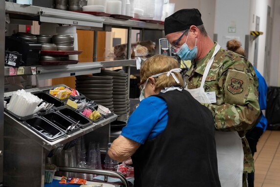 From left, Connie Gregoire of Exeter Hospital’s food and nutrition services and Master Sgt. Chad Logan of the 157th Maintenance Group prepare a patient's food tray Jan. 6, 2022, at Exeter Hospital in Exeter, New Hampshire.
