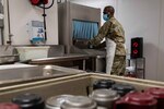 New Hampshire National Guard Senior Airman John Hiki of the 157th Maintenance Group loads a dishwasher during a lull in food services Jan. 6, 2022, at Exeter Hospital, New Hampshire. Hiki, assigned to the NHNG's COVID-19 relief mission Operation Winter Surge, has been working in the hospital’s food and nutrition department for more than a month.