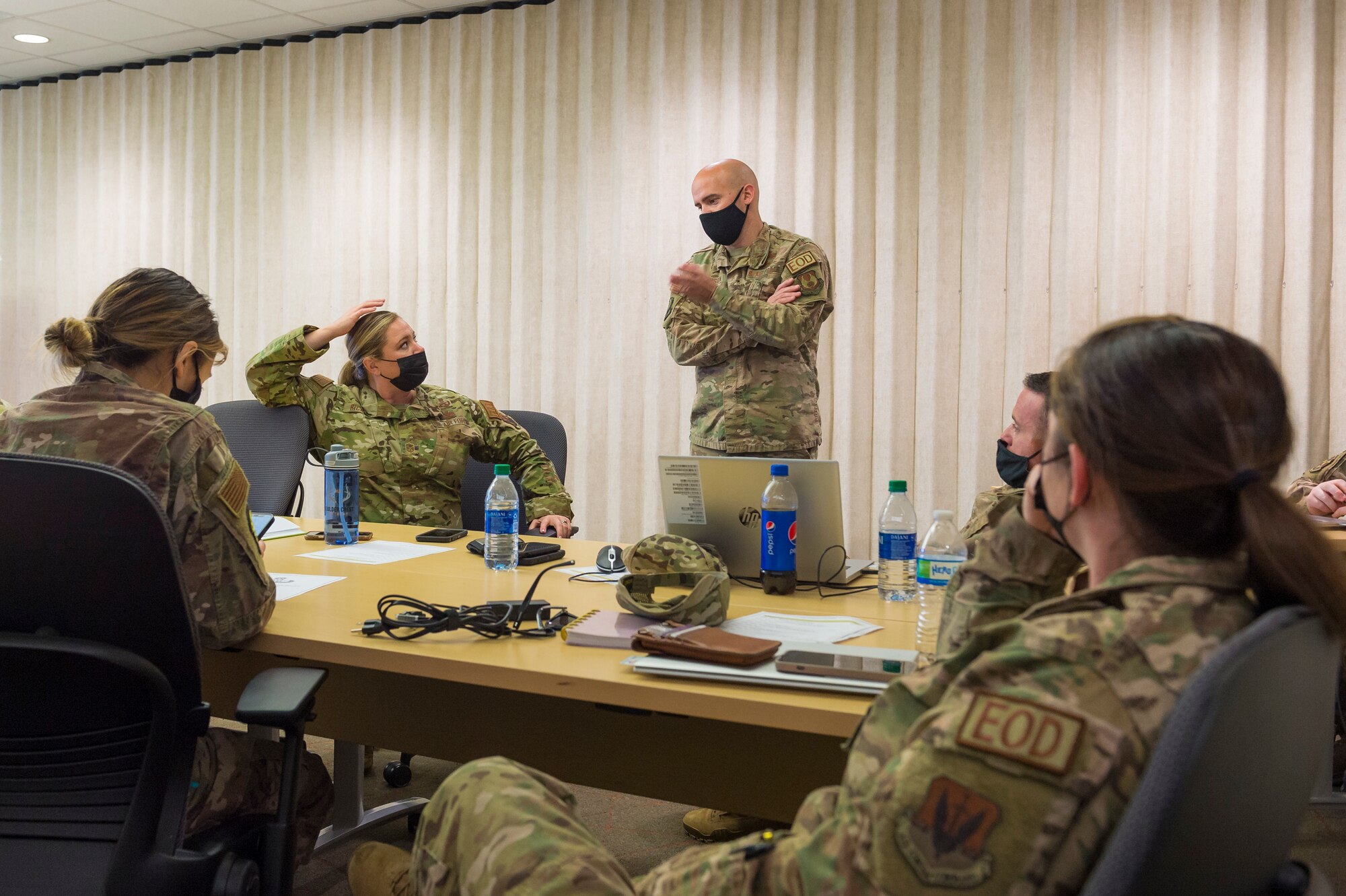 Air Force Explosive Ordnance Disposal Airmen meet with Master Sgt. John Johnson, center, to develop postpartum policy recommendations for the career field's proposed Tier 2 physical fitness test, Joint Base San Antonio-Lackland, Texas, Jan. 6, 2022. The Air Force Installation and Mission Support Center invited female EOD Airmen from around the enterprise to take part in a working group to ensure mother’s needs are taken into account, while still keeping to the higher standard for the career field’s physical demands. Courses of action developed at the meeting will be written into the draft Tier 2 test policy and sent to Headquarters Air Force for approval. (U.S Air Force photo by Malcolm McClendon).