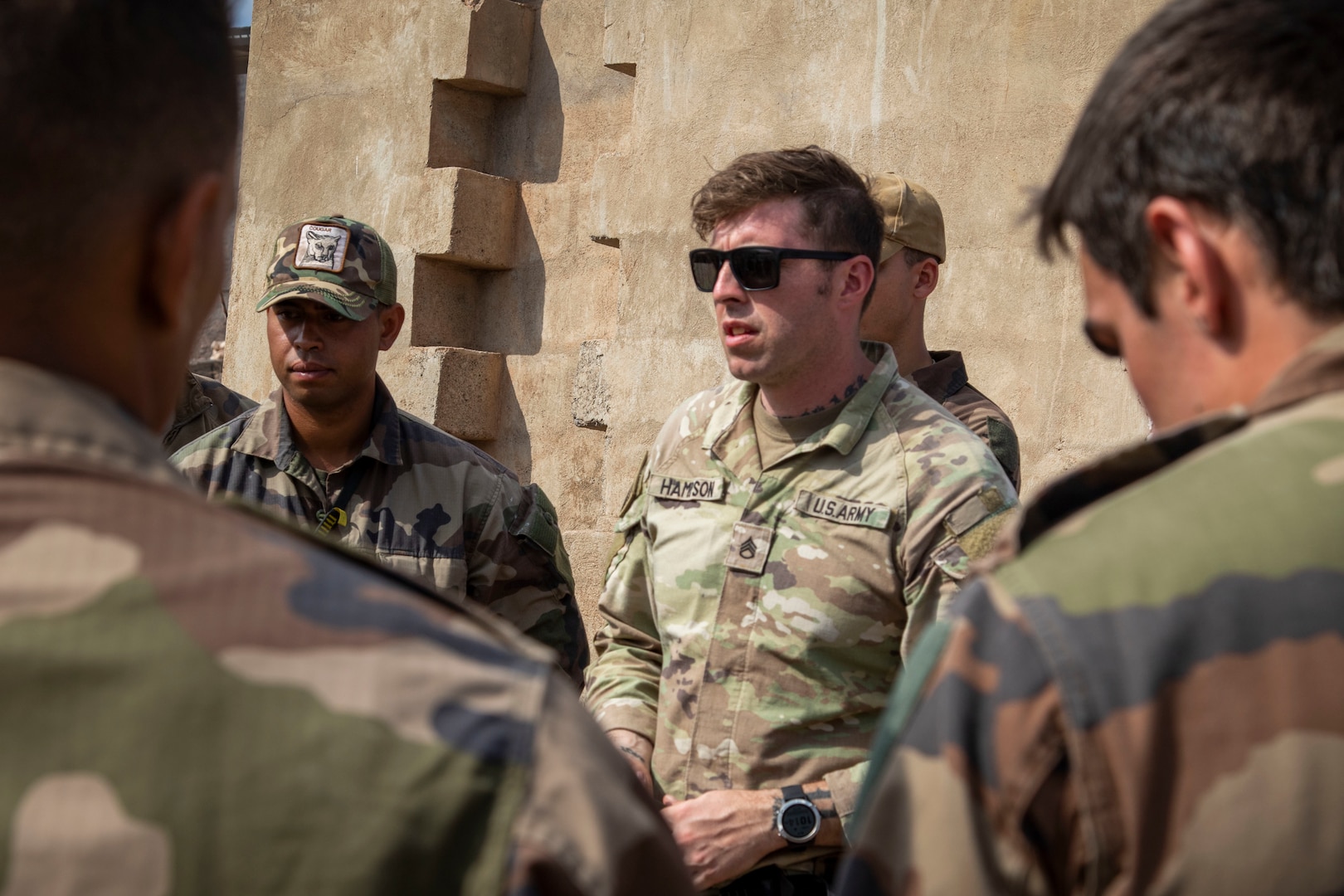 U.S. Army Staff Sgt. John Hampson, an instructor at the U.S. Army Mountain Warfare School, discusses mountain casualty evacuation with French service members with the 5th Overseas Interarms Regiment (5e RIAOM) at the French Combat Training Center at Arta Beach, Djibouti, Dec. 14, 2021. Instructors from the U.S. Army Mountain Warfare School in Jericho, Vt., taught a five-day Joint Expeditionary Mountain Warfare Course on basic military mountaineering skills to French service members in Djibouti to strengthen relationships with international forces working together in the region.