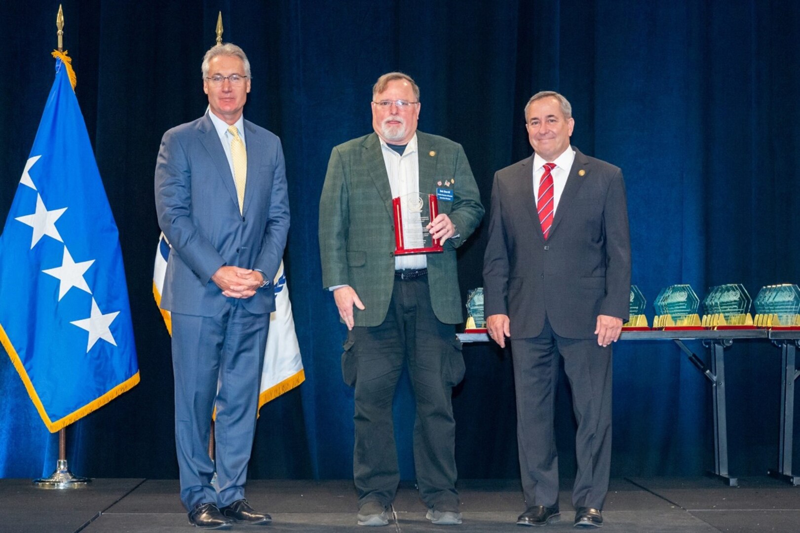 Bob Sherrill, (center), received the Joseph A. Torsani Memorial Award for Lifetime Service and Achievement from Navy retired Vice Admiral William Brown (right) president and CEO of the National Defense Transportation Association and John Dietrich, president & CEO, Atlas Air Worldwide Holdings and Chairman of the NDTA board of directors.