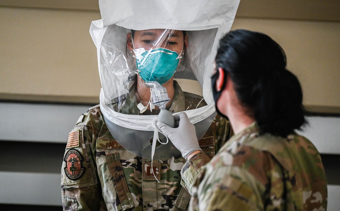 Airman 1st Class Sydni Breitenbach, 15th Operational Medical Readiness Squadron bioenvironmental engineering journeyman, mists Capt. Bonnie Nolan, 15th OMRS family physician, with a sensitivity solution during an N95 mask fit test at Joint Base Pearl Harbor-Hickam, Hawaii, Jan. 7, 2022. The pungent solution was used to test the personal protective gear’s ability to inhibit the introduction of any external contaminants. (U.S. Air Force photo by Staff Sgt. Alan Ricker)