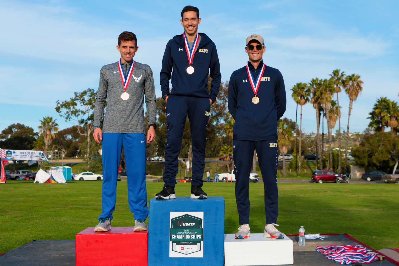 From left to right:  Air Force Major Matthew Williams of Baylor University, Texas; Navy Lt Stanley Linton of NSA Mid-South, Tenn.; and Lt j.g. Zachary Swenson of NAS Corpus Christi, Texas take the men's podium during the 2022 Armed Forces Cross Country Championship held in conjunction with the USA Track and Field National Cross Country Championship at Mission Bay Park in San Diego, Calif. on January 8th.  Runners from the Marine Corps, Navy (with Coast Guard) and Air Force compete for gold.  (Department of Defense Photo - Released)