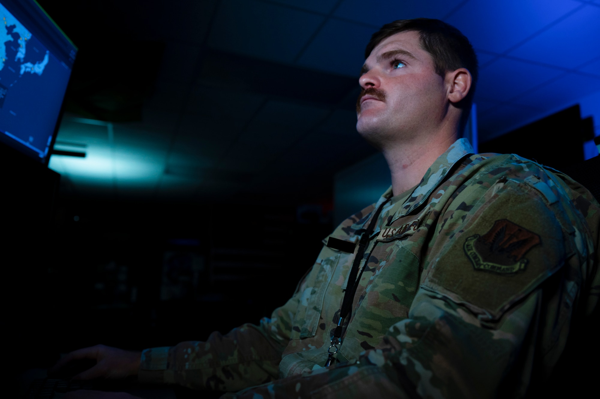 Photo of man sitting looking at a monitor.