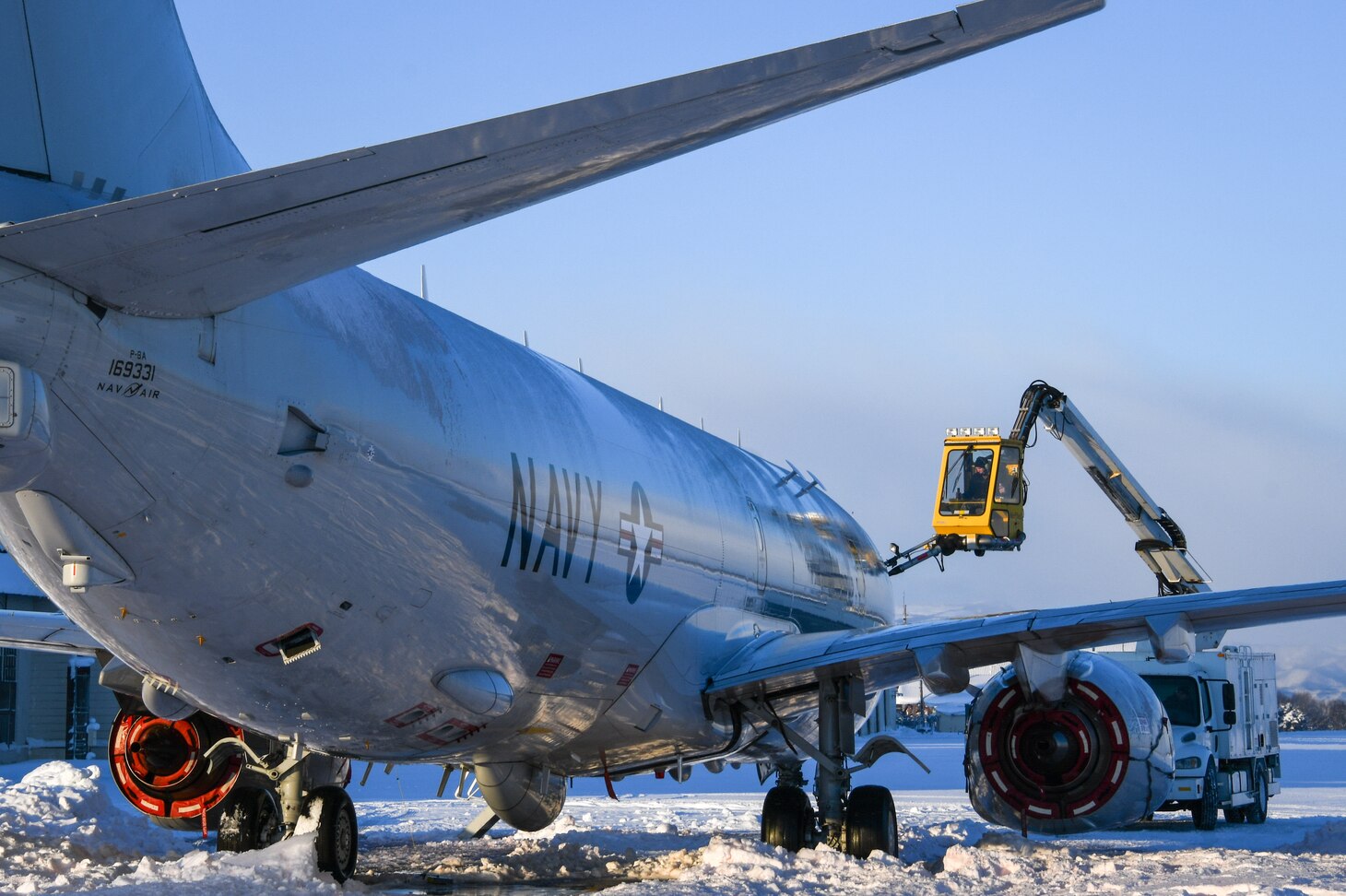 MISAWA, Japan (Jan. 5, 2022) Aviation Electrician’s Mate Airman James Williams, assigned to the “Golden Swordsmen” of Patrol Squadron (VP) 47, operates a de-icing truck to remove snow and ice from a P-8A Poseidon at Misawa Air Base.