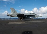 An F/A-18F Super Hornet, from the “Fighting Redcocks” of Strike Fighter Squadron (VFA) 22, makes an arrested landing on the flight deck of the aircraft carrier USS Nimitz (CVN 68) Feb. 19, 2021.