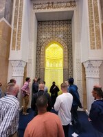 People standing in the doorway of a mosque.