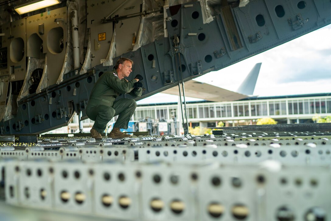 Master Sgt. Don Rix, 701st Airlift Squadron loadmaster, directs a forklift at Johan Adolf Pengel International Airport, Suriname, July 16, 2021. The portable field hospital, valued at $745,000, was donated by U.S. Southern Command (USSOUTHCOM) to the Suriname Ministry of Health to augment their overwhelmed medical capacity brought on by COVID-19. (U.S. Air Force photo by Staff Sgt. Shawn White, July 16, 2021)