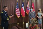 Col. Jorge Salinas (center), the Chilean Army partner nation liaison officer at U.S. Army South, receives an award from Maj. Gen. William L. Thigpen (left), Army South commanding general, during an award ceremony recognizing his two years at the command on January 7, 2022.