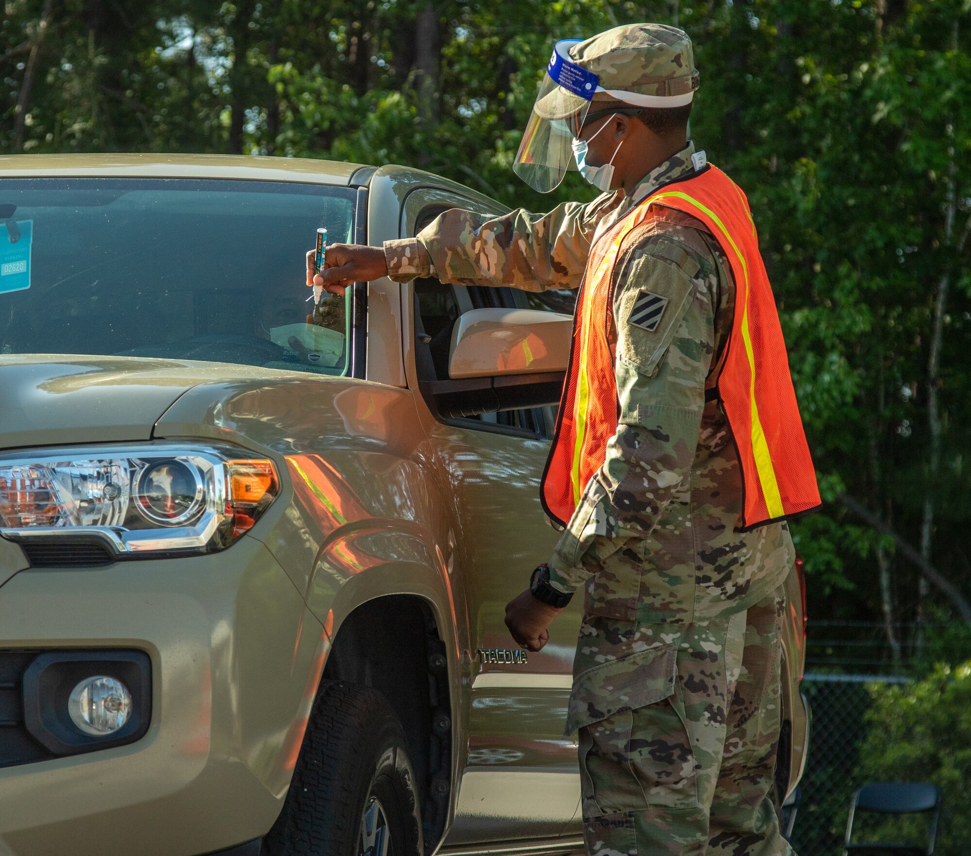 Georgia Army National Guard Sgt. Curtis Bing, a petroleum supply specialist with Foxtrot Company, 148th Brigade Support Battalion, 48th Infantry Brigade Combat Team, marks a vehicle as it enters a mass vaccination site April 13, 2021, in Savannah, Georgia.