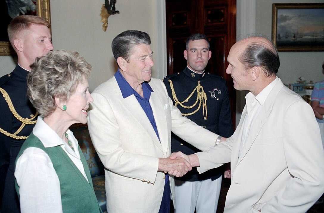 Two men shake hands.