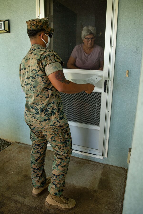 U.S Marine Corps Sgt. Donald B. Pierce, transmission supervisor, 3rd Marine Regiment, 3rd Marine Division, delivers a notification letter to a military resident in Pearl City, Hawaii, Dec. 26, 2021. As part of Task Force KULEANA, Marines passed out letters to military residents affected by the water contamination at Red Hill to provide an update on the efforts to restore clean water to the surrounding communities. (U.S. Marine Corps photo by Lance Cpl. Haley Fourmet Gustavsen)
