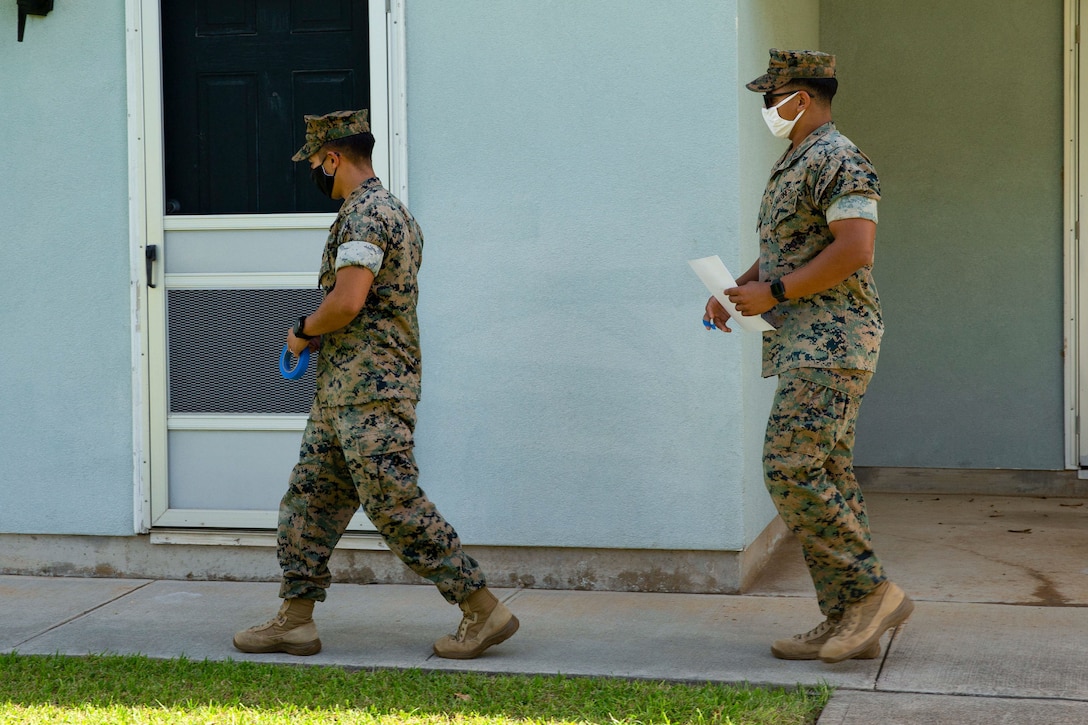 U.S. Marine Corps Sgt. Juan A. Cernar, left, and Sgt. Donald B. Pierce, transmission supervisors, 3rd Marine Regiment, 3rd Marine Division, deliver notification letters to military residents in Pearl City, Hawaii, Dec. 26, 2021.  As part of Task Force KULEANA, Marines passed out letters to military residents affected by the water contamination at Red Hill to provide an update on the efforts to restore clean water to the surrounding communities. (U.S. Marine Corps photo by Lance Cpl. Haley Fourmet Gustavsen)
