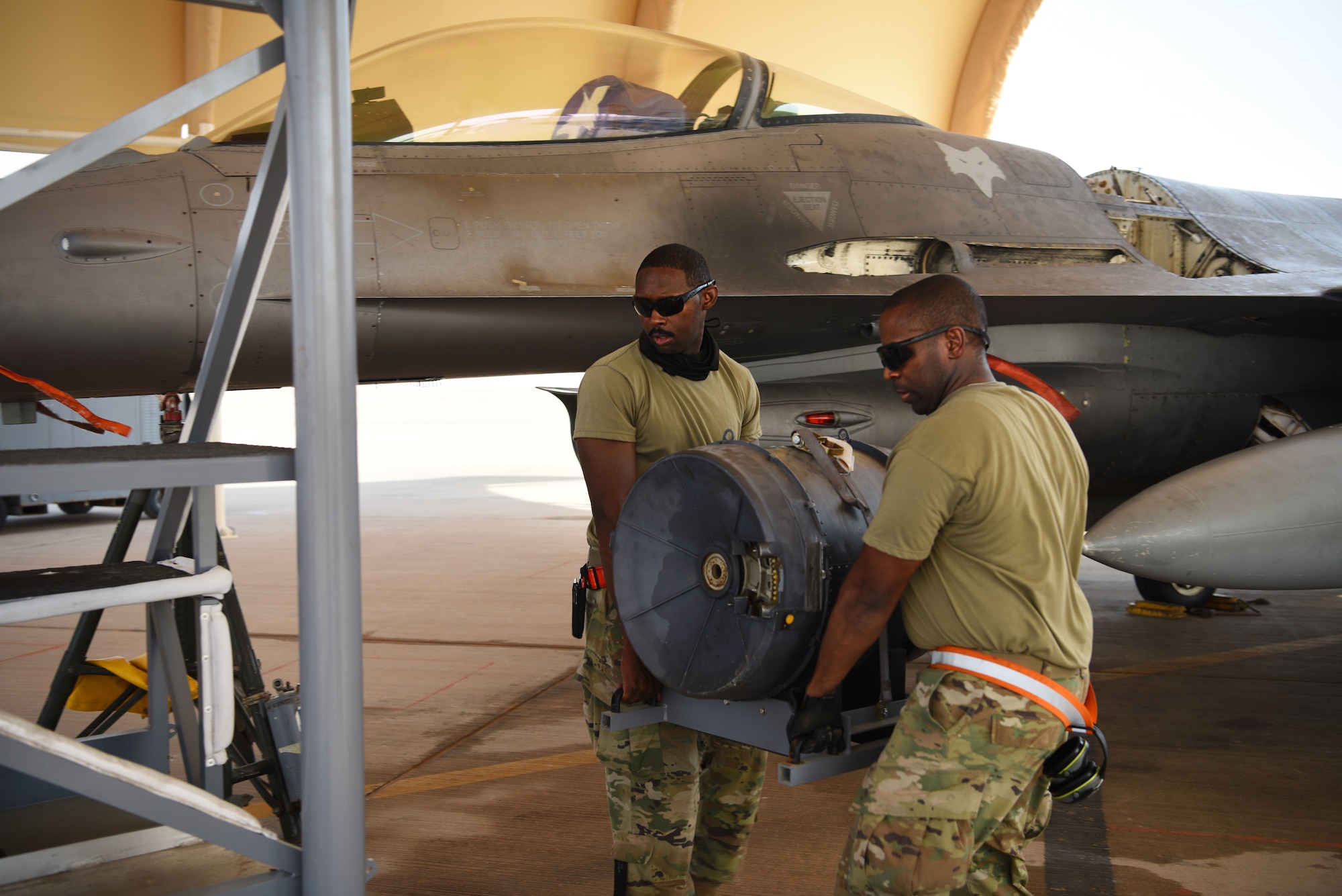 U.S. Air Force Staff Sgt. Kajuan Archer (left) and U.S. Air Force Staff Sgt. Rick Ingram, 378th Expeditionary Maintenance Squadron armament backshop personnel, remove parts of an M61A1 Vulcan cannon from an F-16 Fighting Falcon fighter jet at Prince Sultan Air Base, Kingdom of Saudi Arabia, June 8, 2021. The "Swamp Fox" Airmen from the South Carolina Air National Guard are deployed to PSAB to project combat power and help bolster defensive capabilities against potential threats in the region. (U.S. Air National Guard photo by Senior Master Sgt. Carl Clegg)