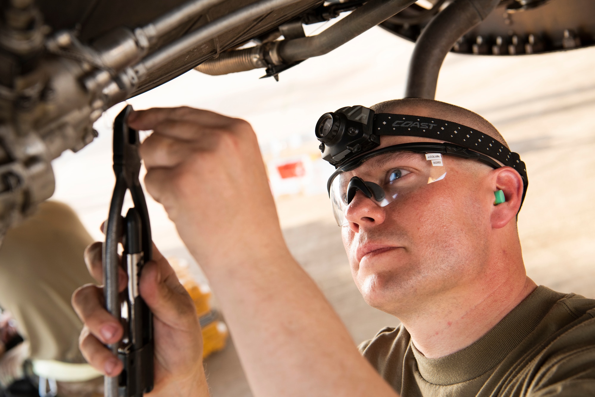 U.S. Air Force Tech. Sgt. Jarvis Colvin, 157th Expeditionary Fighter Generation Squadron propulsion technician, secures an engine component with safety wire on an F-16 Fighting Falcon at Prince Sultan Air Base, Kingdom of Saudi Arabia, July 9, 2021. The "Swamp Fox" Airmen from the South Carolina Air National Guard are deployed to PSAB to project combat power and help bolster defensive capabilities against potential threats in the region. (U.S. Air National Guard photo by Senior Master Sgt. Carl Clegg)